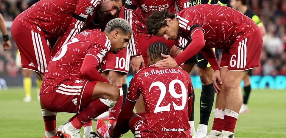 Jugadores de Liverpool apoyando a compañero caído