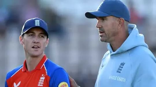 Entrenador hablando con jugador de cricket en el campo