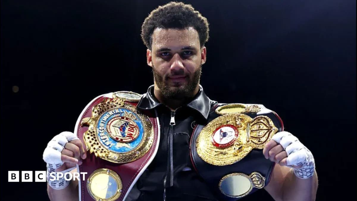 Boxeador sosteniendo cinturones de campeonato en ring