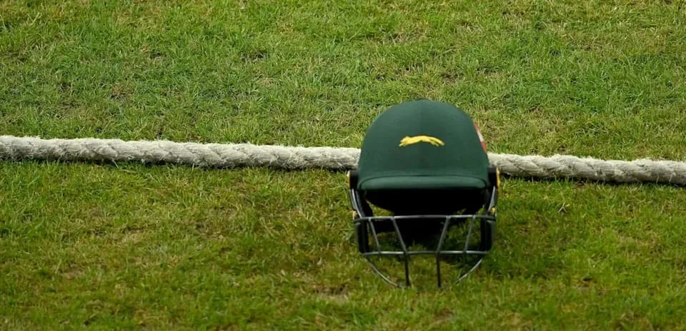 Casco de cricket sobre el césped junto a una cuerda