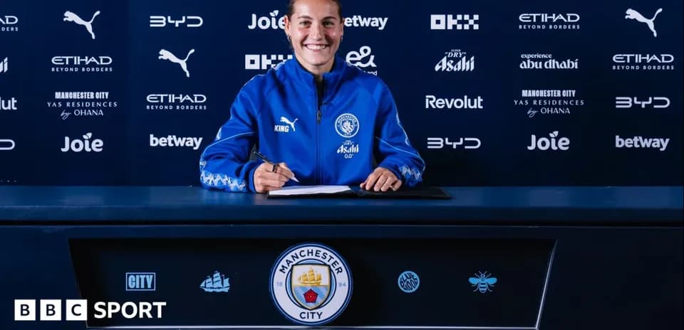 Jugadora firmando contrato en la mesa de prensa