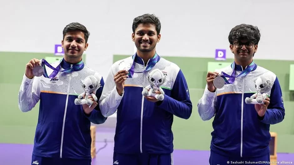 Tres atletas sosteniendo medallas y trofeos en podio Tres atletas sosteniendo medallas y trofeos en podio