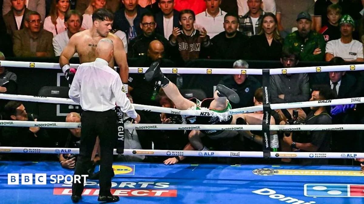 Boxeador caído fuera del ring durante pelea Boxeador caído fuera del ring durante pelea