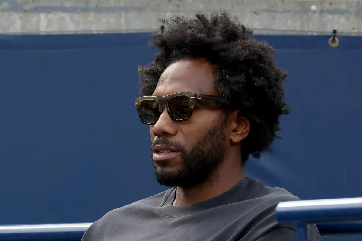 Hombre con gafas oscuras sentado en tribuna Hombre con gafas oscuras sentado en tribuna