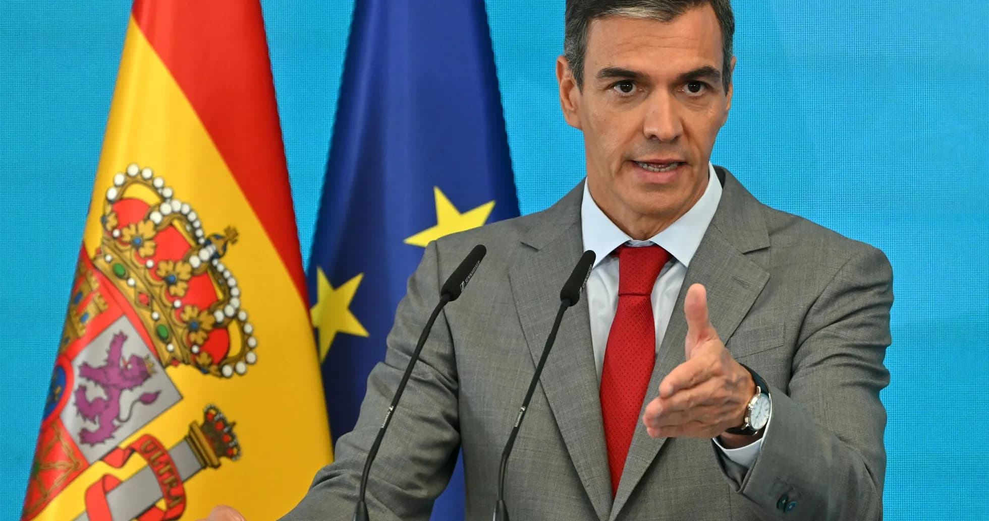 Hombre hablando en conferencia con banderas de España y UE Hombre hablando en conferencia con banderas de España y UE
