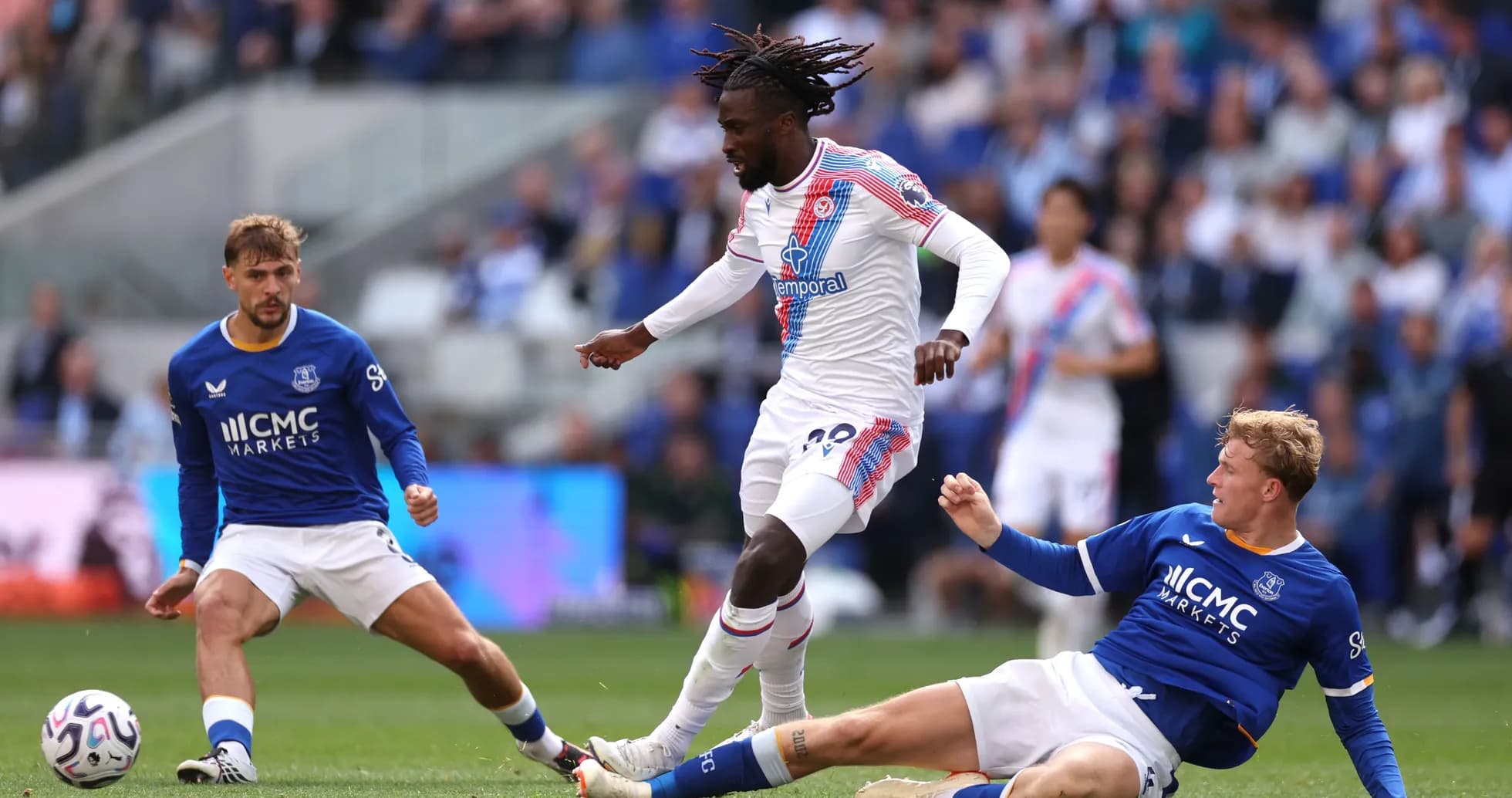 Jugador de Crystal Palace esquivando a dos rivales de Everton Jugador de Crystal Palace esquivando a dos rivales de Everton