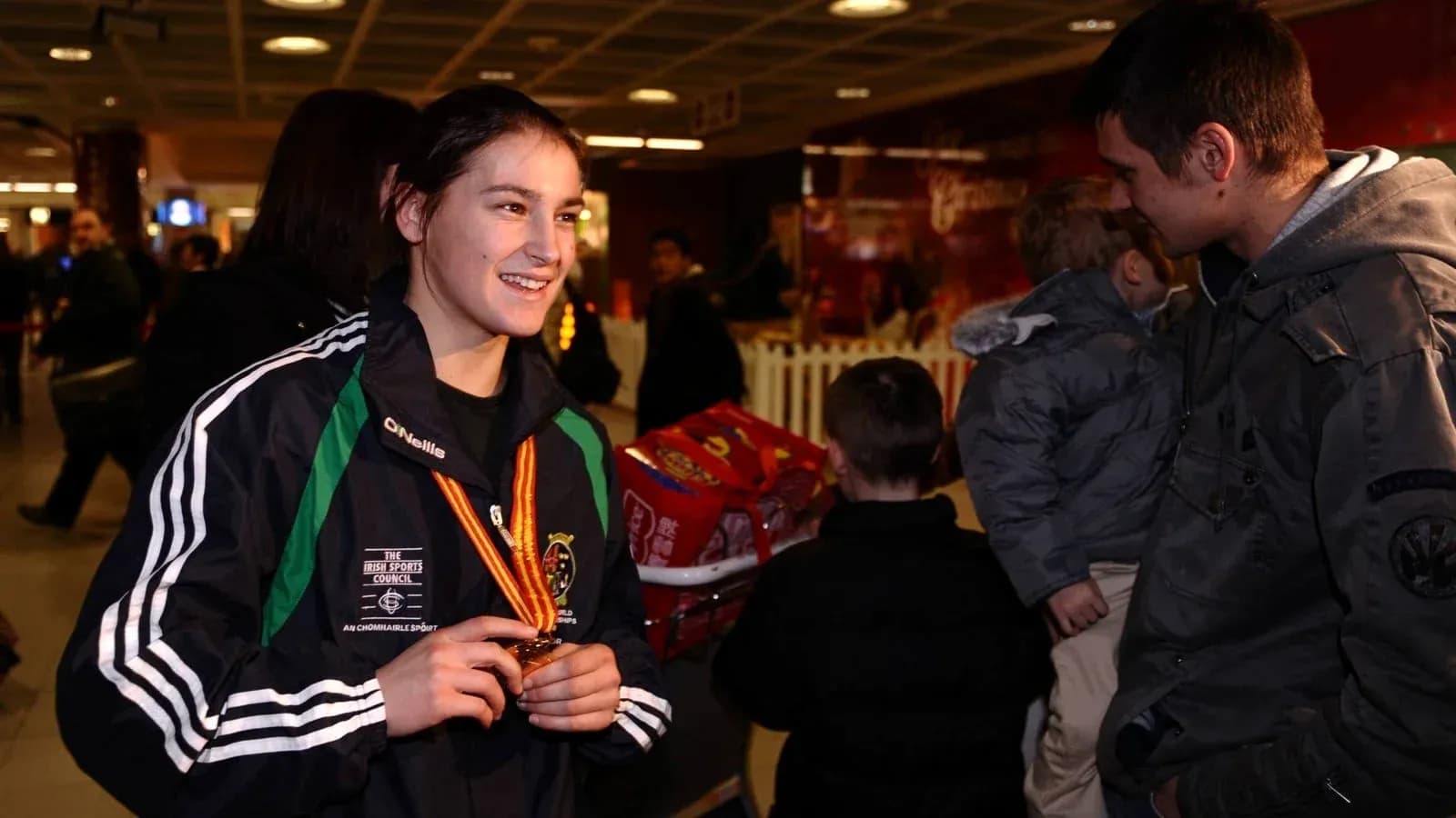 Atleta sonriente con medalla en el aeropuerto Atleta sonriente con medalla en el aeropuerto
