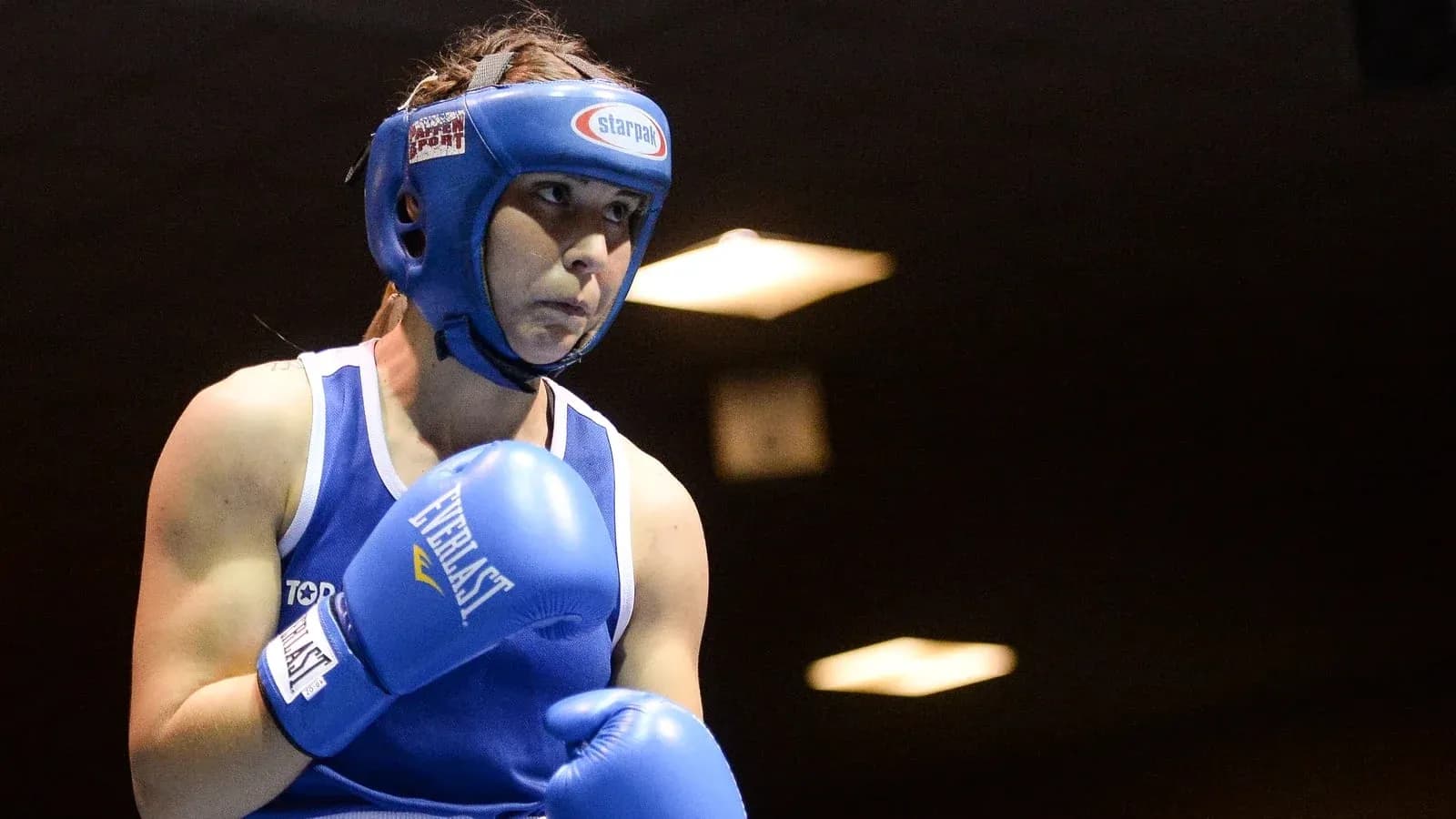 Boxeadora con guantes azules en el ring Boxeadora con guantes azules en el ring