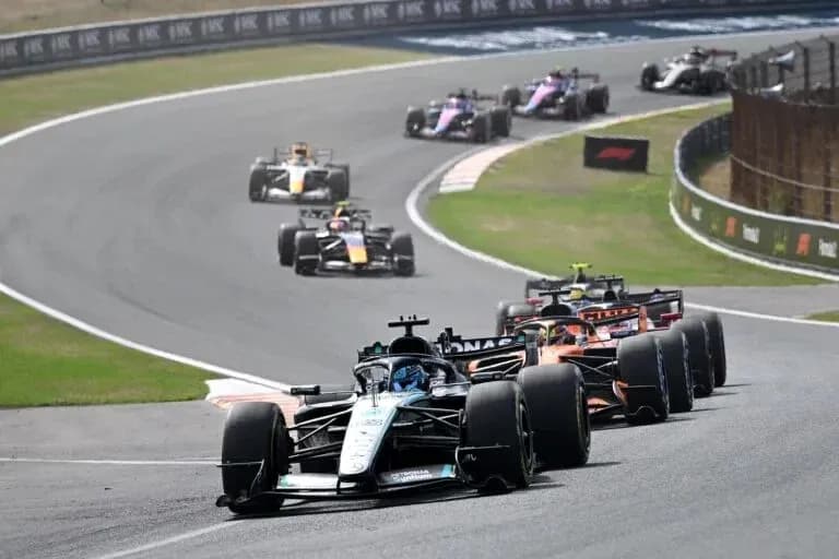 Varios coches de Fórmula 1 compitiendo en curva Varios coches de Fórmula 1 compitiendo en curva