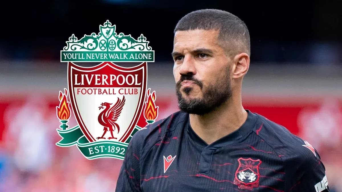 Jugador de fútbol con escudo de Liverpool detrás Jugador de fútbol con escudo de Liverpool detrás