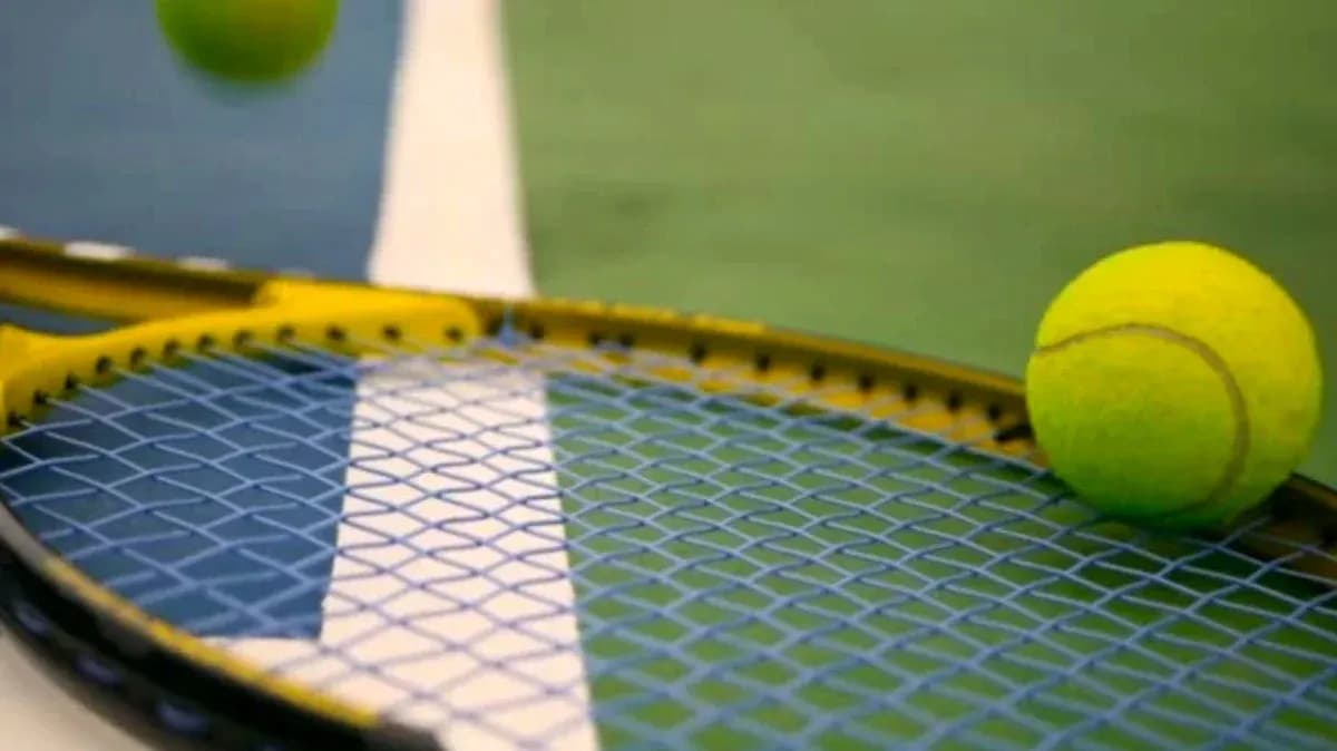 Pelota de tenis sobre una raqueta amarilla Pelota de tenis sobre una raqueta amarilla