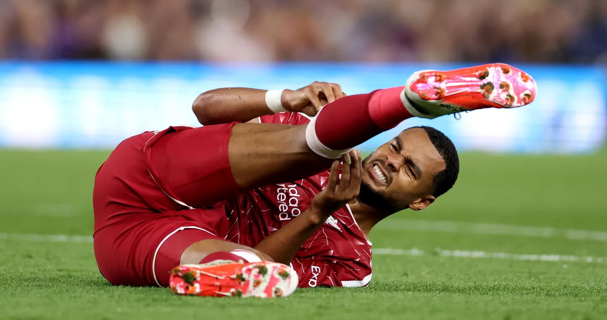 Jugador de Liverpool en el suelo con lesión Jugador de Liverpool en el suelo con lesión