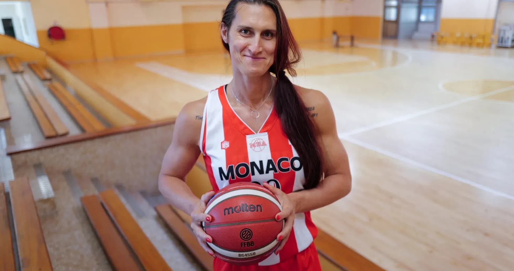 Jugadora de baloncesto sosteniendo una pelota en cancha Jugadora de baloncesto sosteniendo una pelota en cancha