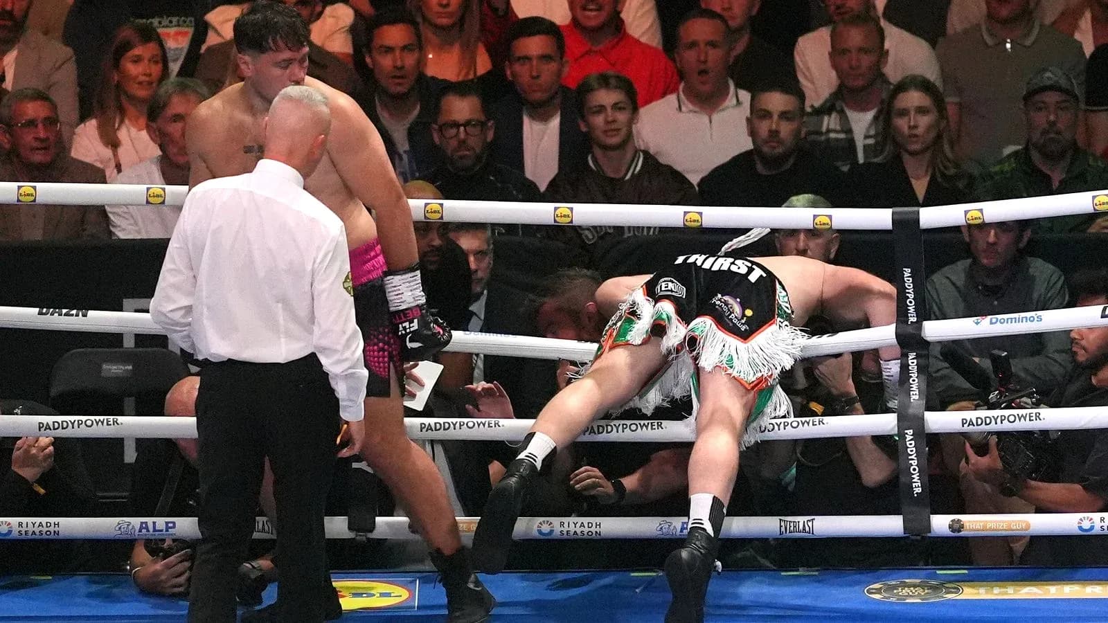 Boxeador caído en el ring tras un golpe Boxeador caído en el ring tras un golpe