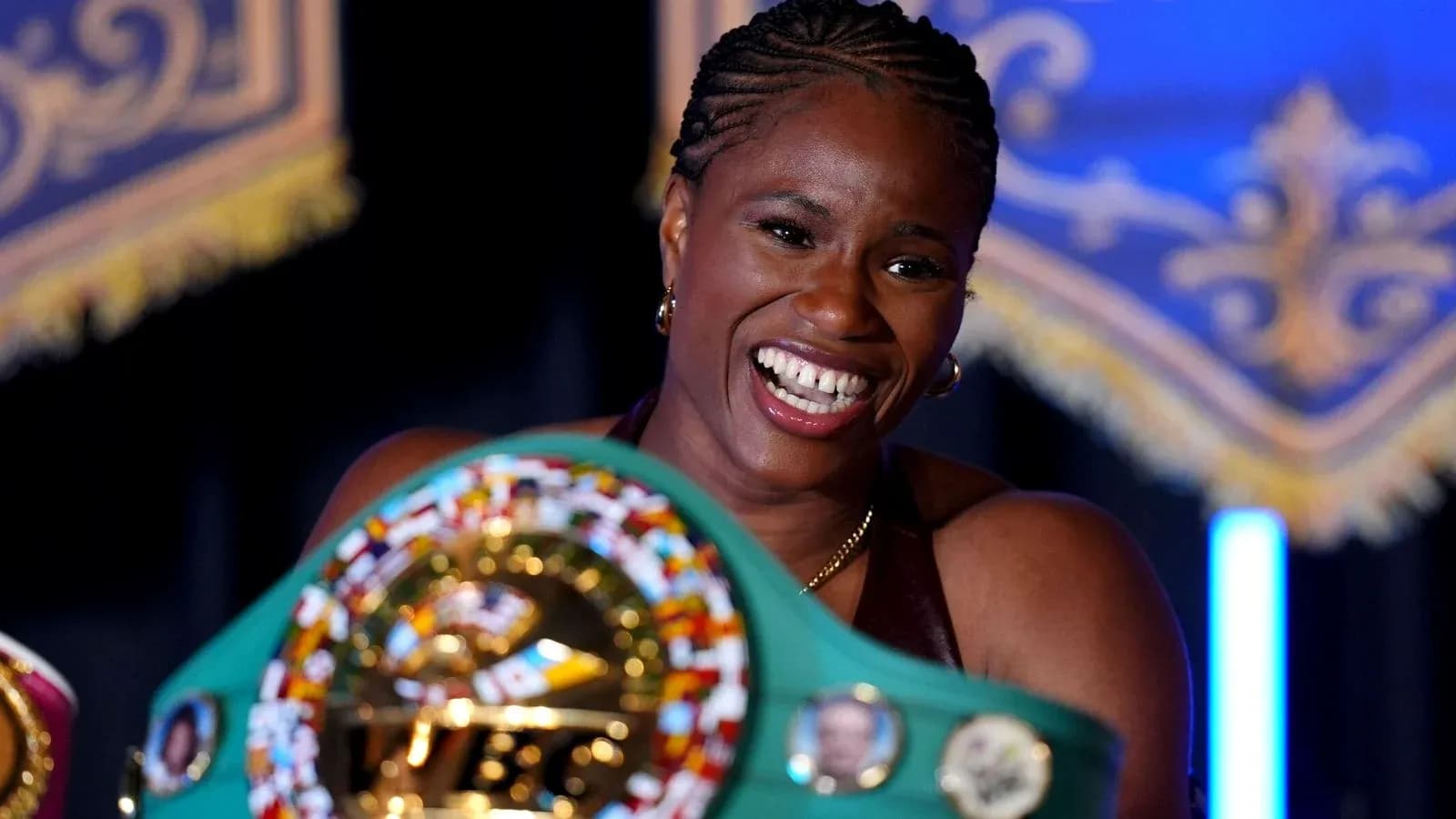Boxeadora sosteniendo cinturón de campeona y sonriendo Boxeadora sosteniendo cinturón de campeona y sonriendo