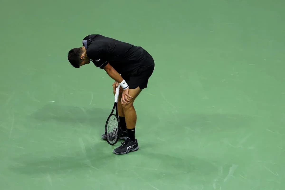 Jugador de tenis agachado sosteniendo su raqueta Jugador de tenis agachado sosteniendo su raqueta