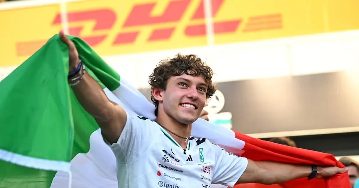 Piloto con bandera italiana celebrando en el podio Piloto con bandera italiana celebrando en el podio