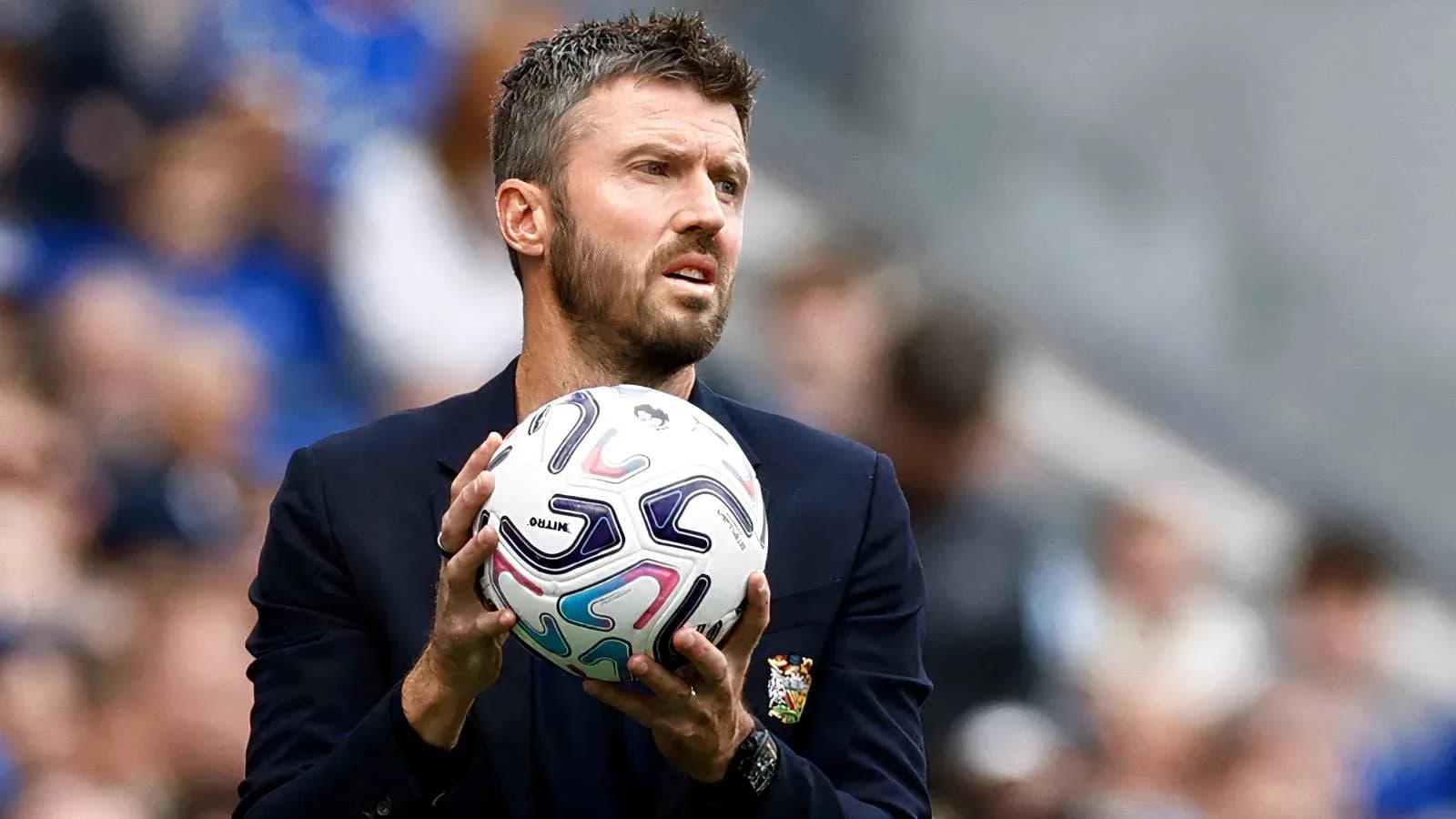 Entrenador sosteniendo un balón de fútbol en el campo Entrenador sosteniendo un balón de fútbol en el campo