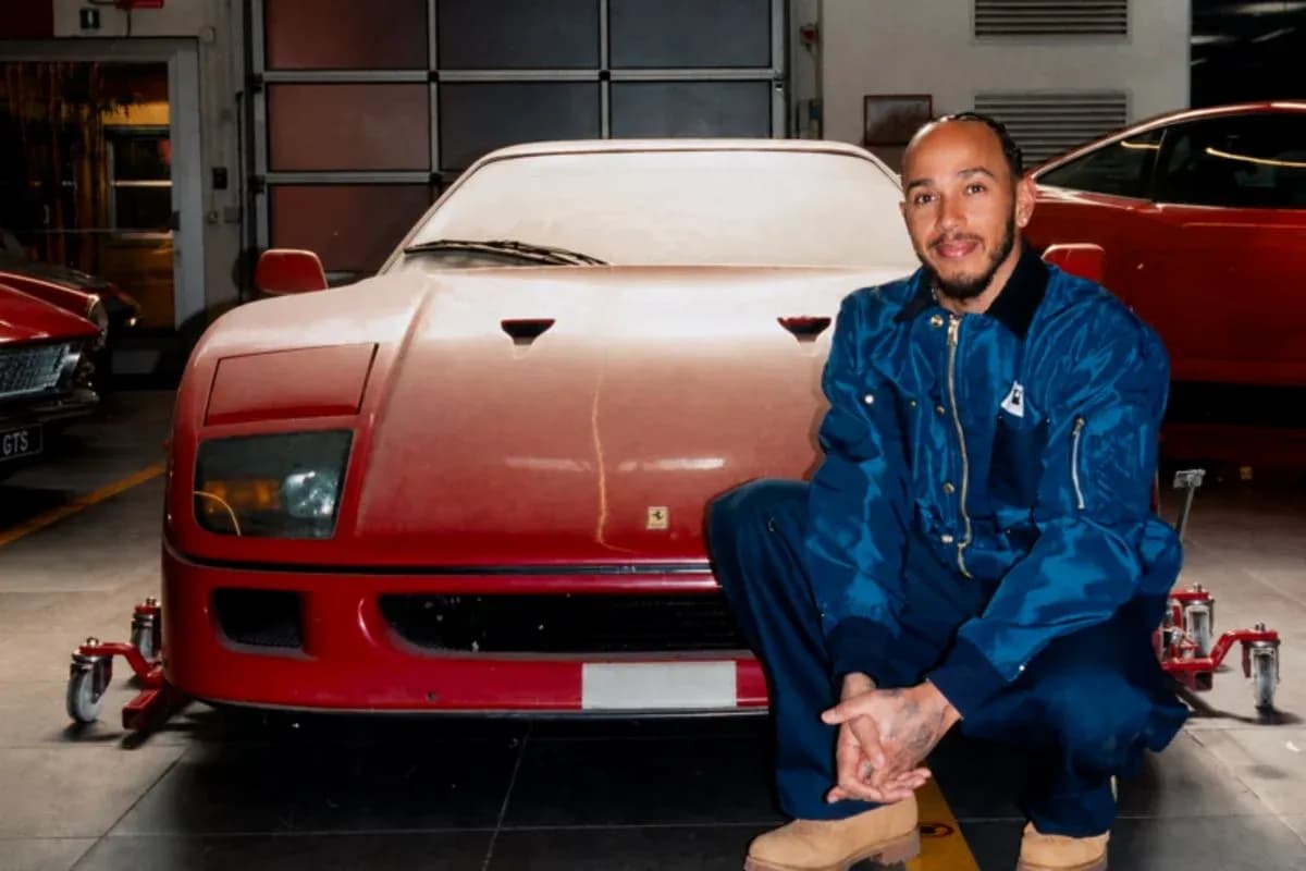 Hombre posando junto a un coche rojo en taller Hombre posando junto a un coche rojo en taller