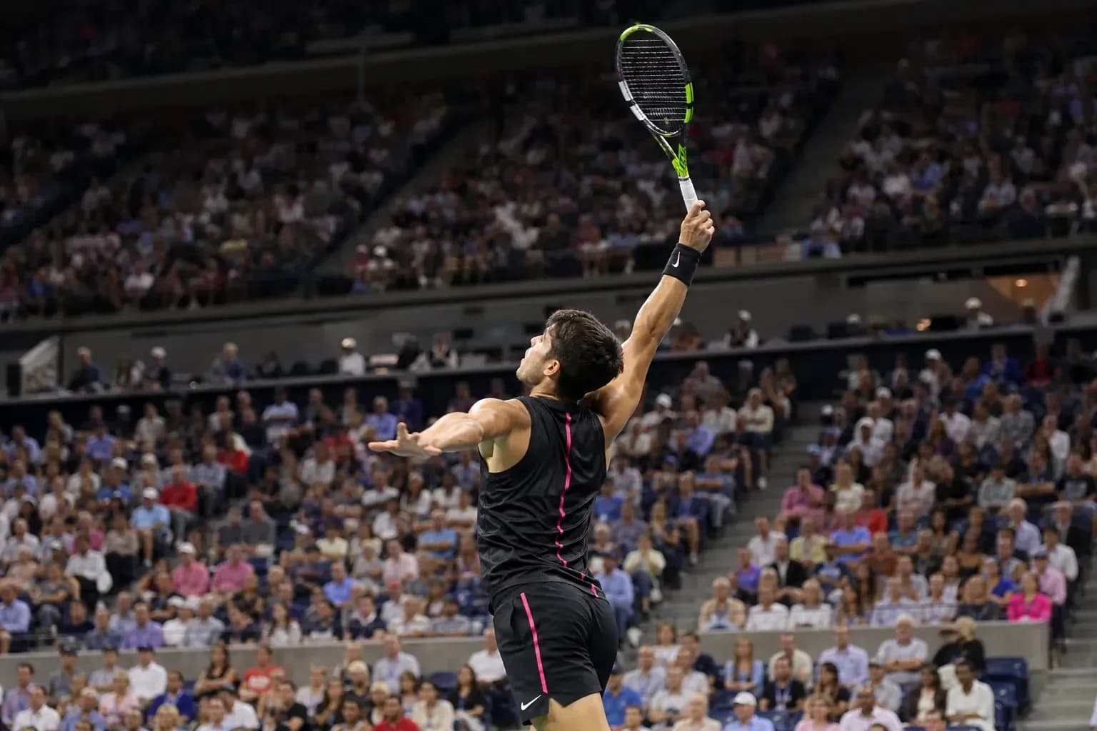 Jugador de tenis sirviendo en partido ante público Jugador de tenis sirviendo en partido ante público
