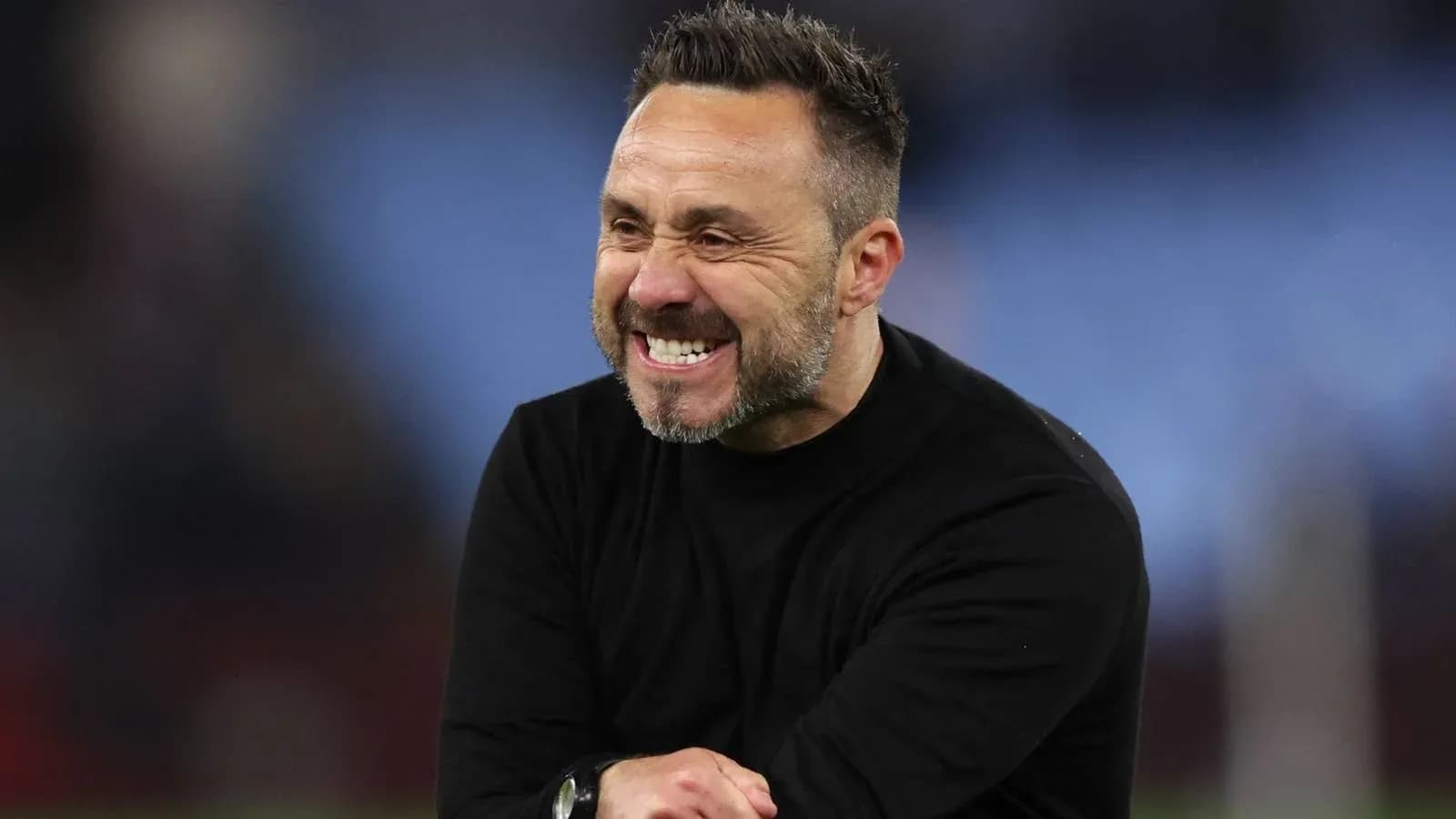 Entrenador sonriendo durante el partido en el banquillo Entrenador sonriendo durante el partido en el banquillo