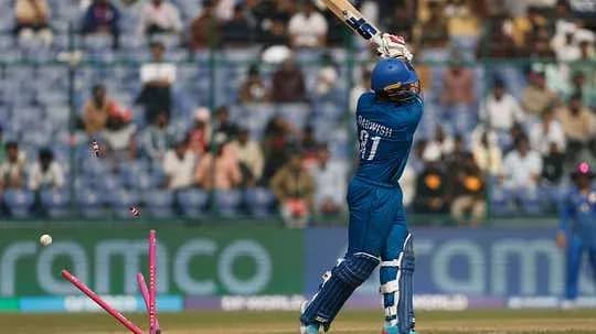 Batsman hitting ball with stumps visible behind Batsman hitting ball with stumps visible behind