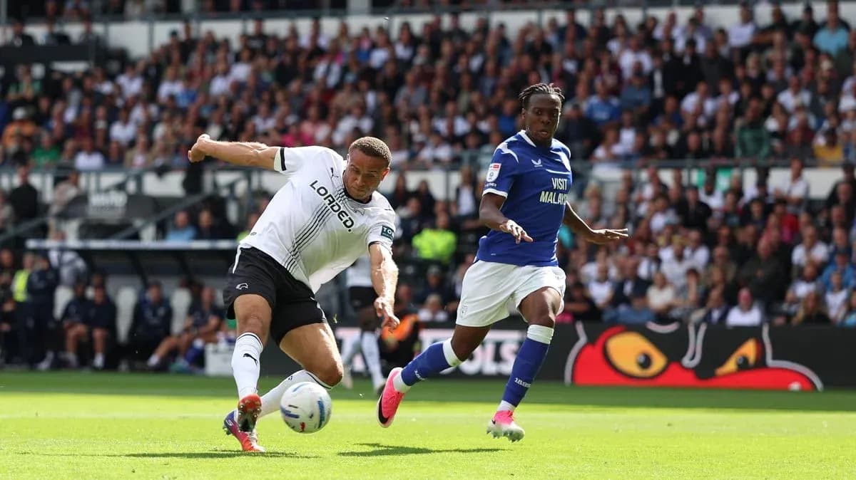 Jugador de Derby County deslizándose por el balón Jugador de Derby County deslizándose por el balón
