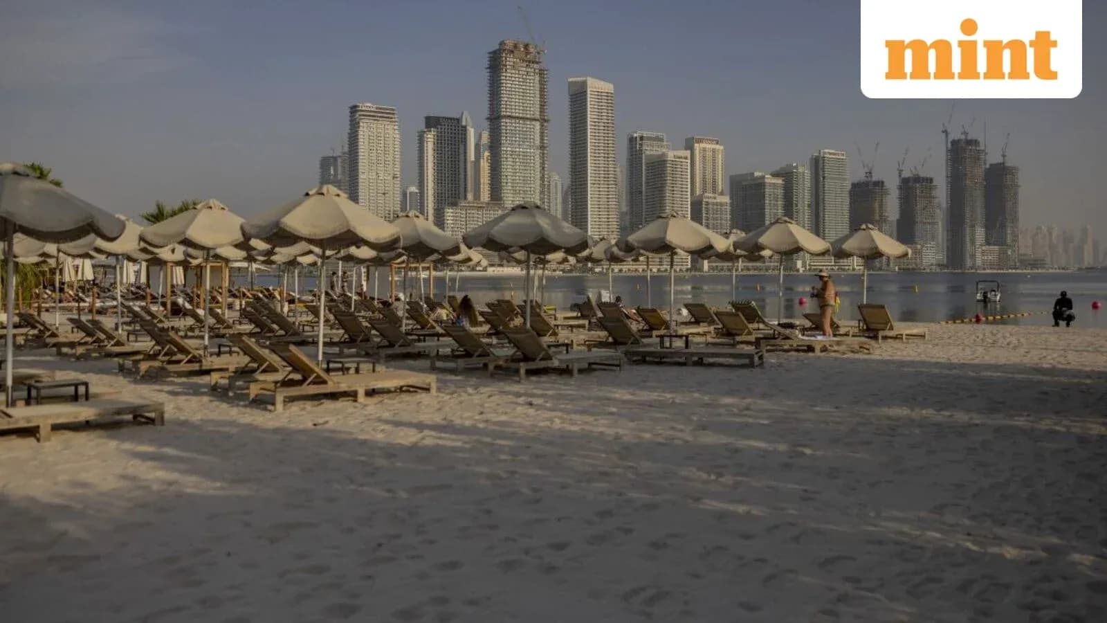 Playa con tumbonas y edificios altos al fondo Playa con tumbonas y edificios altos al fondo