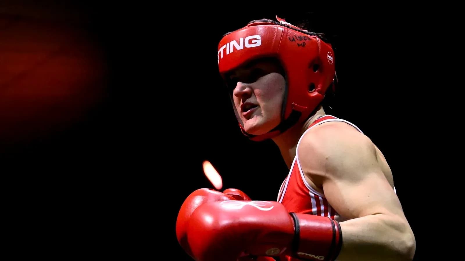 Boxeadora con casco rojo y guantes en acción Boxeadora con casco rojo y guantes en acción