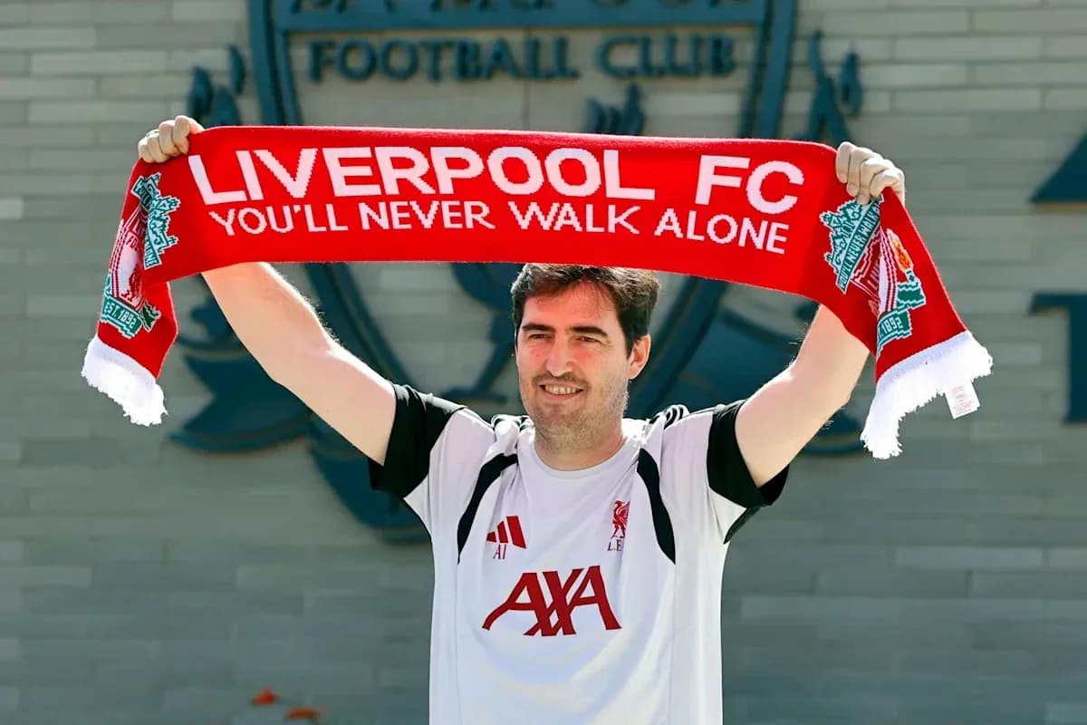 Jugador sostiene bufanda de Liverpool FC en anuncio Jugador sostiene bufanda de Liverpool FC en anuncio