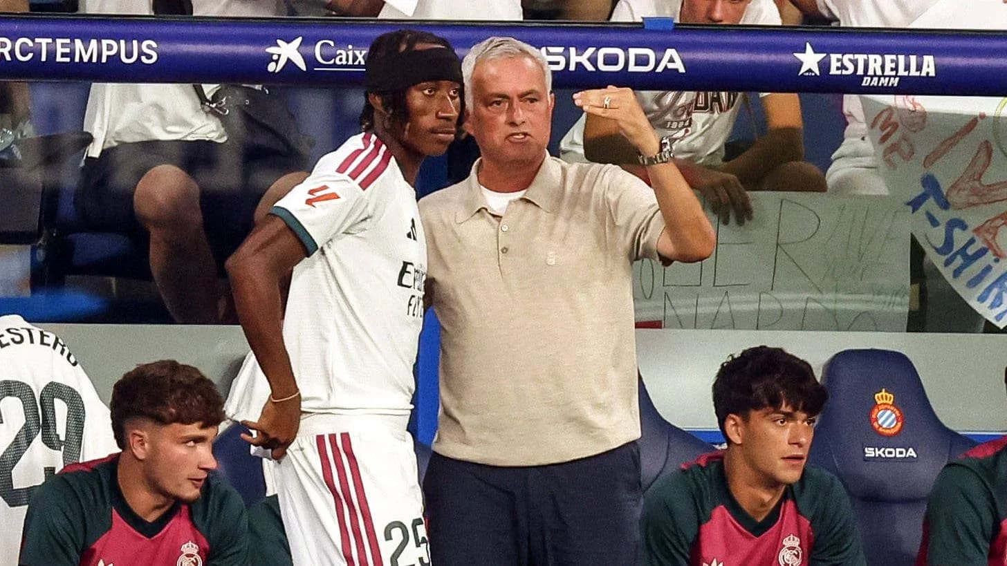 Entrenador hablando con jugador en banquillo Entrenador hablando con jugador en banquillo