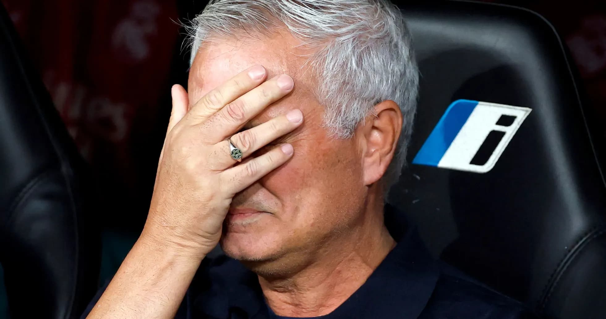 Entrenador cubriendo su rostro con la mano en el banquillo Entrenador cubriendo su rostro con la mano en el banquillo