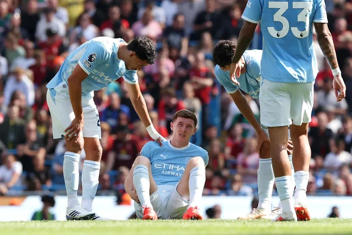 Jugador de Manchester City sentado en el campo con compañeros Jugador de Manchester City sentado en el campo con compañeros