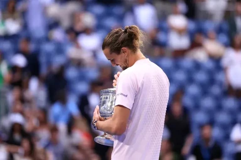 Jugador sosteniendo trofeo tras ganar torneo de tenis Jugador sosteniendo trofeo tras ganar torneo de tenis