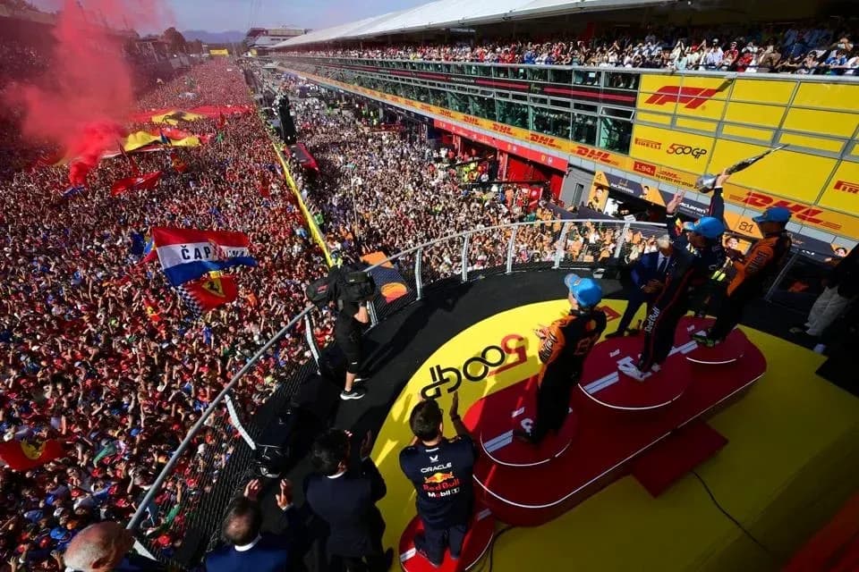 Podio con pilotos celebrando frente a multitud Podio con pilotos celebrando frente a multitud