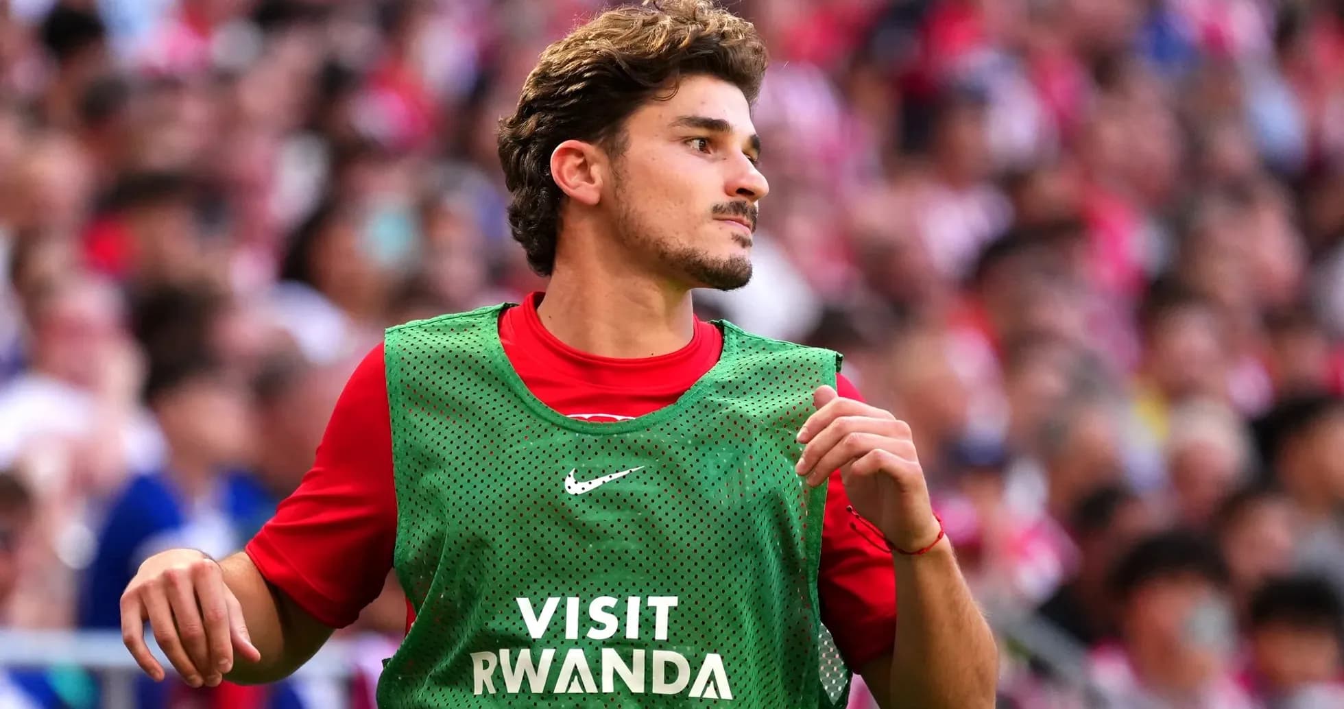 Jugador en el banquillo con chaleco verde Jugador en el banquillo con chaleco verde